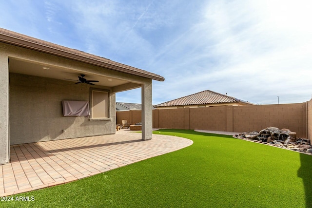 view of yard with ceiling fan and a patio area