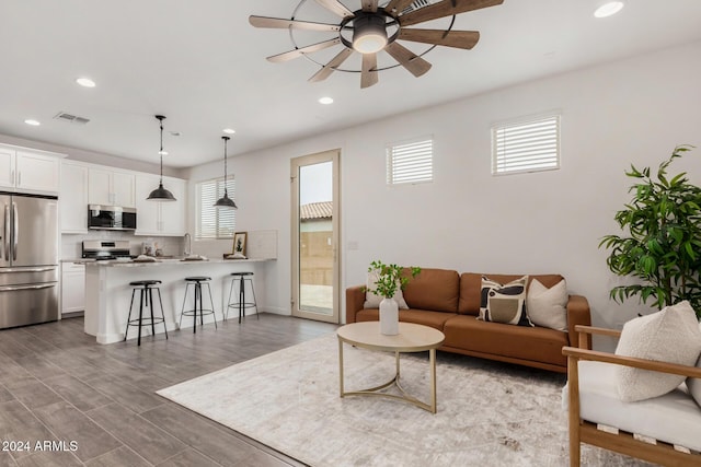 living room featuring ceiling fan and dark wood-type flooring