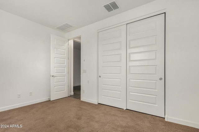 unfurnished bedroom featuring carpet and a closet