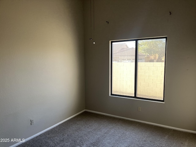 unfurnished room with carpet and baseboards