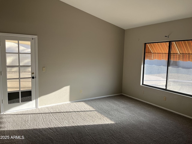 carpeted empty room featuring baseboards