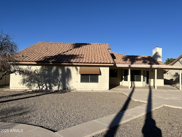 view of front of home with a patio area, a tiled roof, and stucco siding