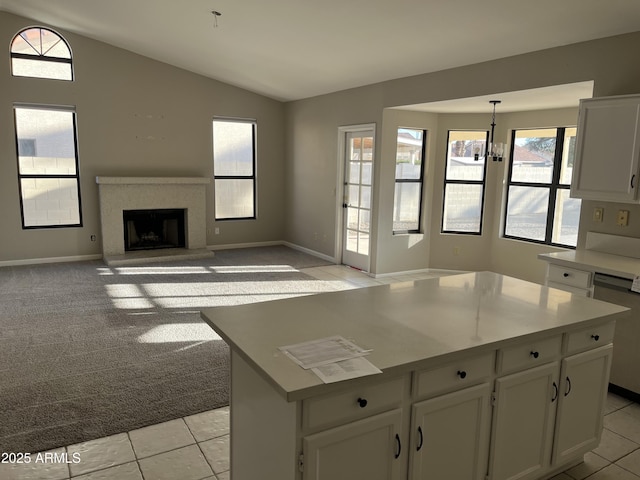 kitchen with vaulted ceiling, light carpet, dishwasher, and white cabinets