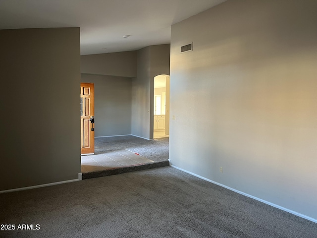 carpeted spare room with arched walkways, high vaulted ceiling, visible vents, and baseboards