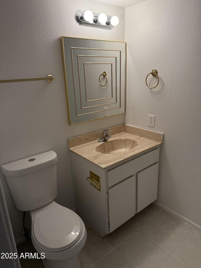 bathroom featuring vanity, tile patterned floors, and toilet