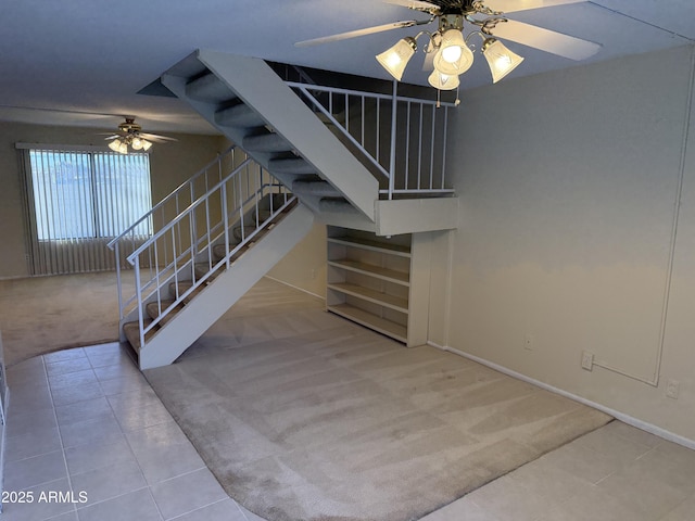 stairs with carpet floors and ceiling fan