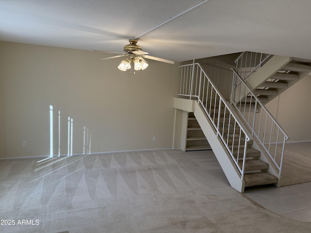 unfurnished living room with a textured ceiling, ceiling fan, and carpet