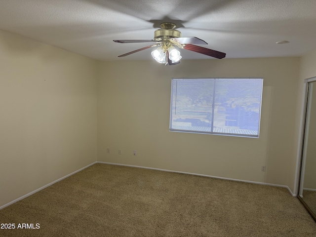 spare room featuring ceiling fan, carpet floors, and a textured ceiling