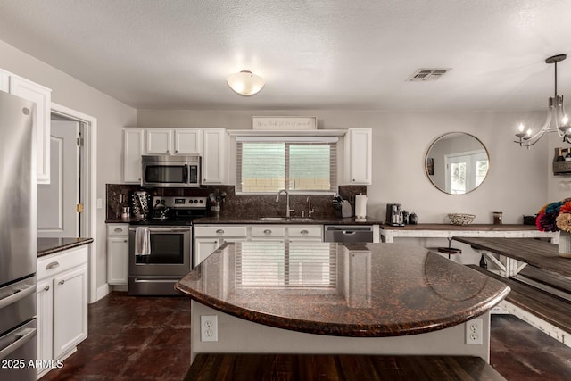 634 W Aviary Way, Gilbert, AZ 85233 - kitchen with stainless steel appliances, a sink, white cabinetry, backsplash, and dark stone countertops