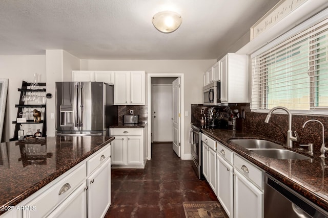 634 W Aviary Way, Gilbert, AZ 85233 - kitchen with stainless steel appliances, a sink, white cabinetry, tasteful backsplash, and dark stone countertops