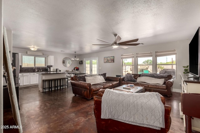 634 W Aviary Way, Gilbert, AZ 85233 - living area featuring finished concrete flooring, a ceiling fan, a chandelier, and a textured ceiling