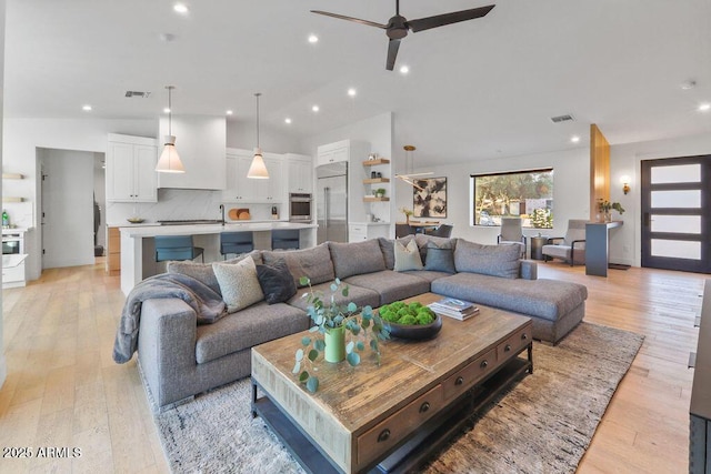 living area with recessed lighting, visible vents, and light wood-style flooring