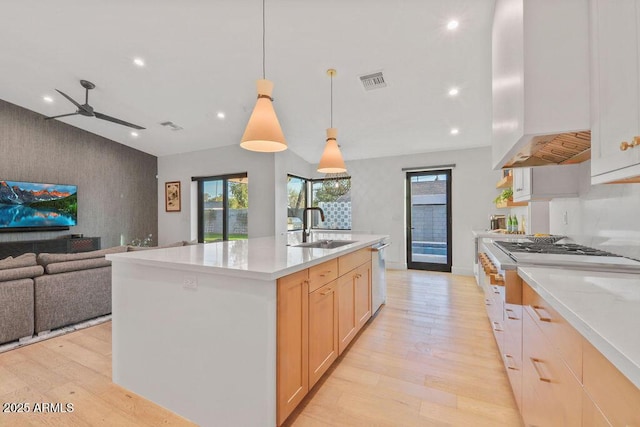 kitchen featuring a center island with sink, light countertops, a sink, and open floor plan