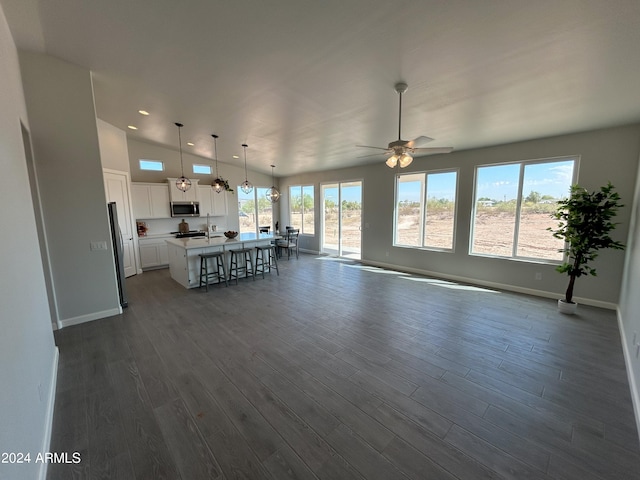 unfurnished living room featuring dark hardwood / wood-style flooring, a wealth of natural light, and ceiling fan