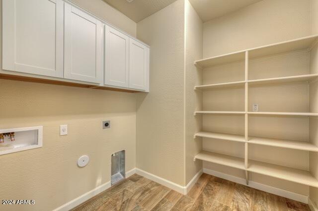 laundry area featuring cabinets, light hardwood / wood-style flooring, washer hookup, and hookup for an electric dryer