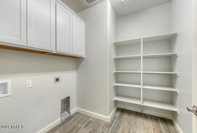 laundry area with cabinets, hookup for a washing machine, dark wood-type flooring, and hookup for an electric dryer