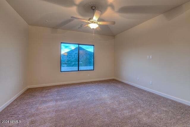 spare room with light carpet and ceiling fan