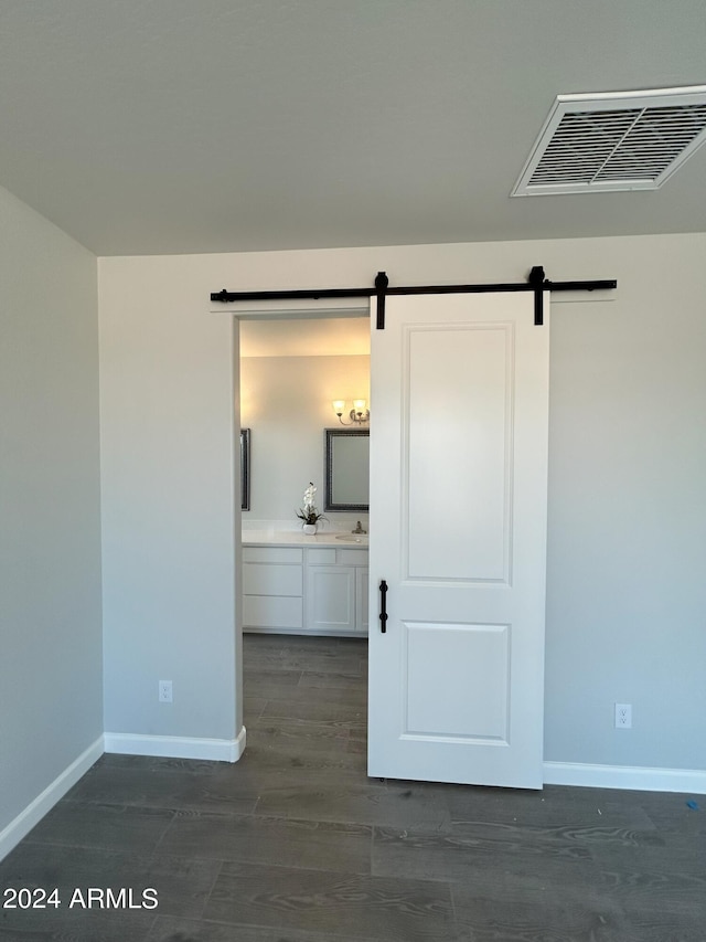 spare room featuring dark hardwood / wood-style flooring and a barn door