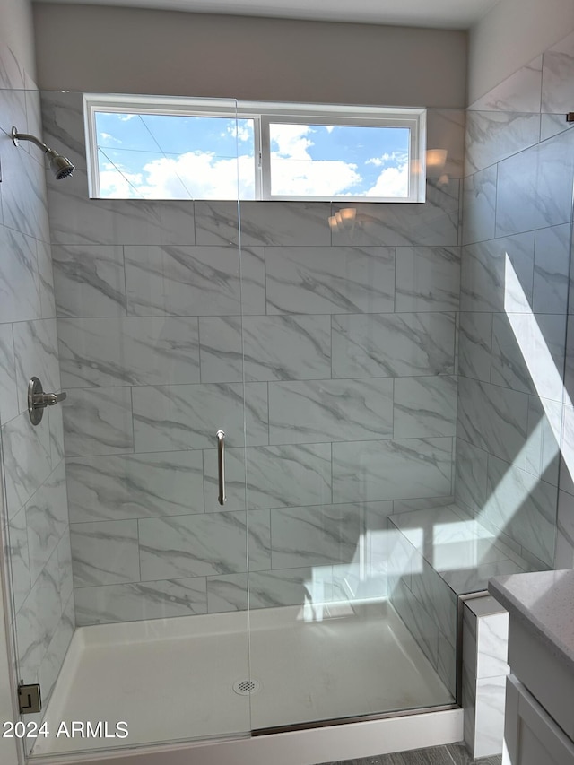 bathroom with vanity, a healthy amount of sunlight, and a shower with shower door