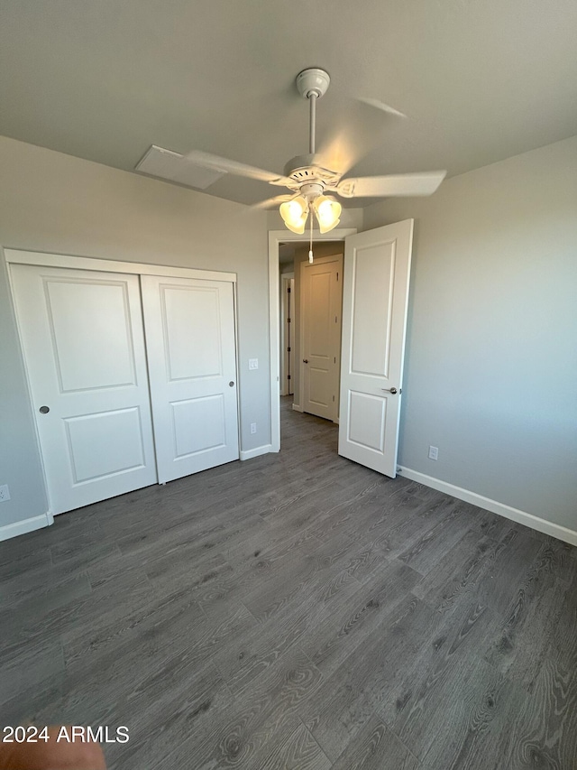 unfurnished bedroom featuring ceiling fan, a closet, and dark wood-type flooring