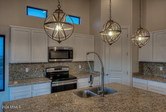 kitchen featuring white cabinets, decorative backsplash, sink, and appliances with stainless steel finishes