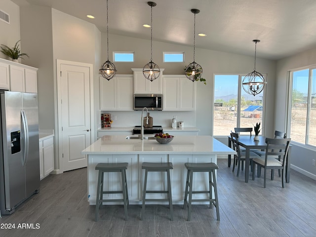 kitchen with stainless steel appliances, a kitchen island with sink, pendant lighting, white cabinets, and dark hardwood / wood-style floors