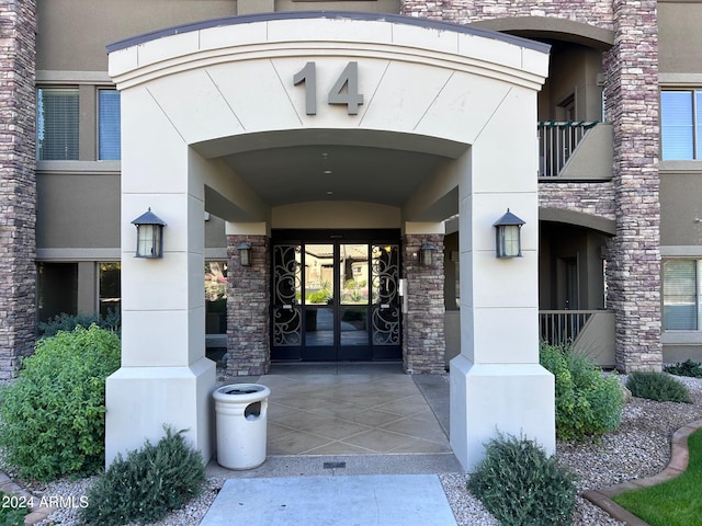 property entrance featuring a balcony and french doors