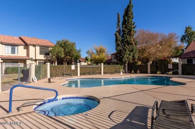 view of swimming pool with a patio area and a hot tub