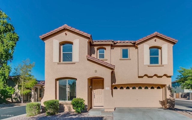 mediterranean / spanish-style home with a garage