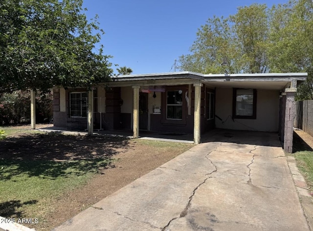 3112 W Taylor St, Phoenix, AZ 85009 - view of front facade featuring concrete driveway, fence, stucco siding, and an attached carport