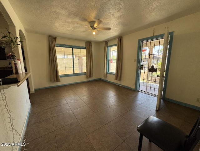 3112 W Taylor St, Phoenix, AZ 85009 - unfurnished room with baseboards, dark tile patterned floors, a textured ceiling, and ceiling fan