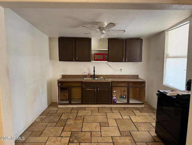 3112 W Taylor St, Phoenix, AZ 85009 - kitchen with a ceiling fan, black range with electric stovetop, dark brown cabinets, a sink, and stone tile flooring
