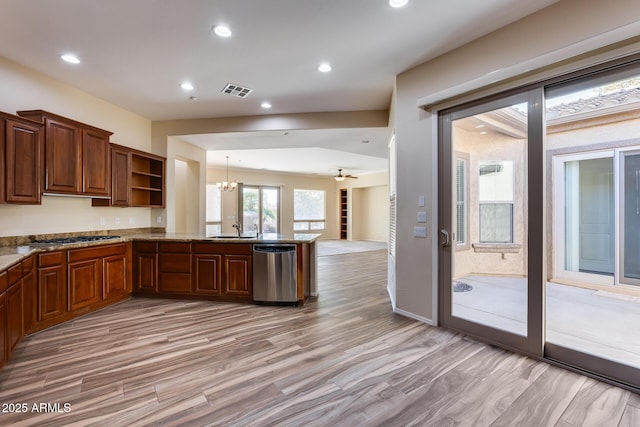 kitchen featuring pendant lighting, sink, stainless steel appliances, kitchen peninsula, and light wood-type flooring