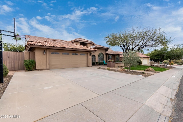 mediterranean / spanish house featuring a gate, driveway, stucco siding, a garage, and a tiled roof