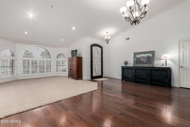 unfurnished living room featuring visible vents, baseboards, ornamental molding, hardwood / wood-style floors, and a notable chandelier