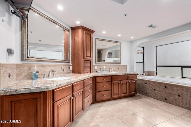 bathroom featuring tile patterned floors, visible vents, a sink, tasteful backsplash, and double vanity