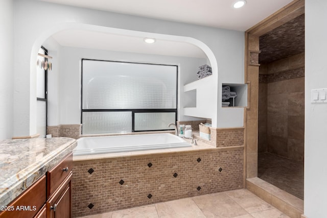 full bath with vanity, a bath, tile patterned flooring, and tiled shower