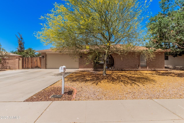single story home with brick siding, fence, and concrete driveway