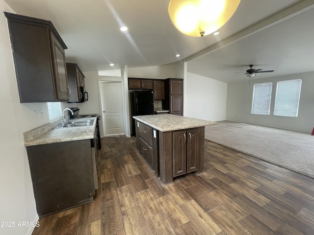 kitchen with a sink, dark brown cabinetry, dark wood-style flooring, a ceiling fan, and a kitchen island