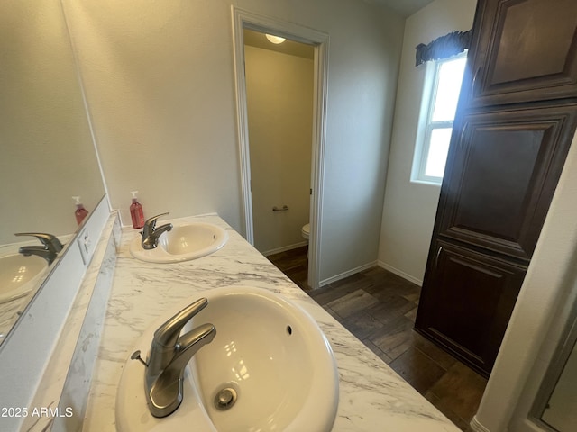 bathroom featuring a sink, double vanity, and toilet
