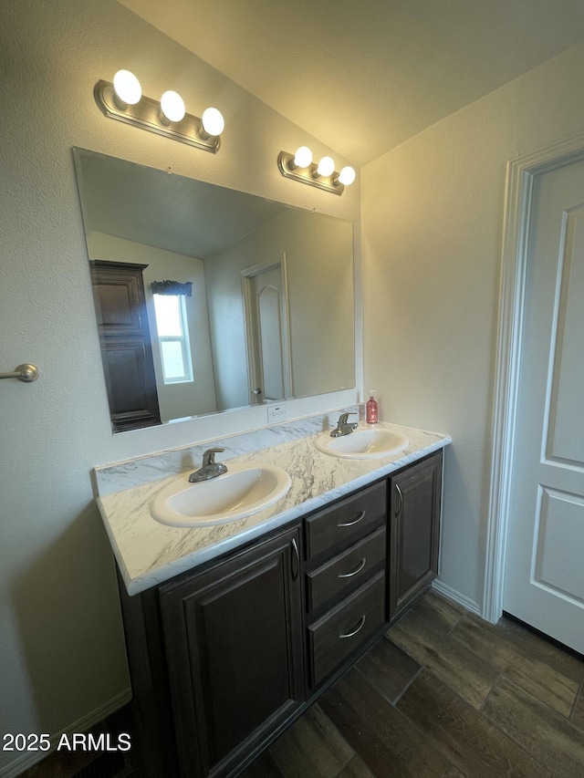 bathroom with double vanity, a sink, and wood finished floors