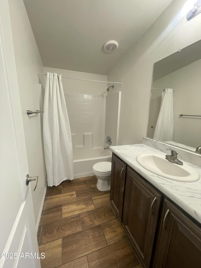 bathroom featuring toilet, wood finished floors, vanity, visible vents, and shower / bath combination with curtain