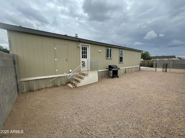 back of property featuring entry steps and fence