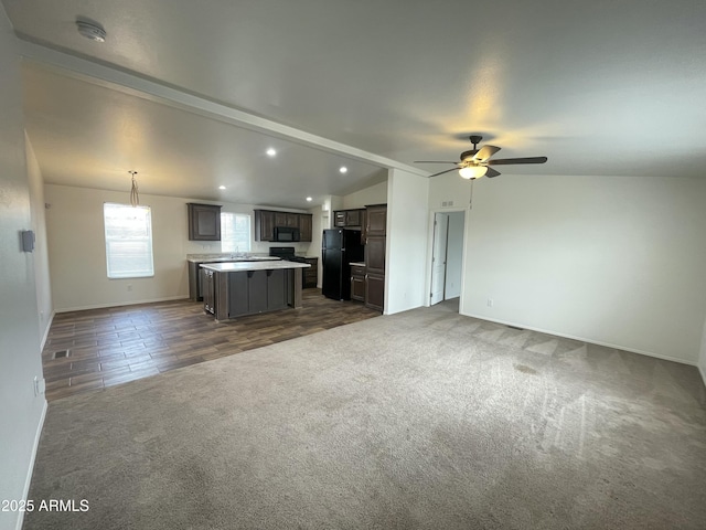 unfurnished living room featuring recessed lighting, baseboards, dark colored carpet, ceiling fan, and vaulted ceiling with beams