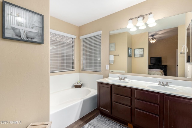 full bathroom featuring a garden tub, ensuite bathroom, a sink, and ceiling fan