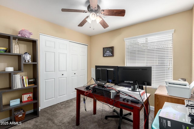 carpeted office space featuring ceiling fan
