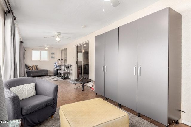 tiled living area with ceiling fan
