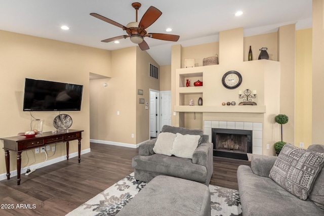 living area featuring visible vents, built in shelves, dark wood-style flooring, ceiling fan, and a tile fireplace