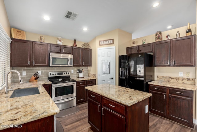 kitchen featuring appliances with stainless steel finishes, dark wood-style flooring, a sink, and visible vents