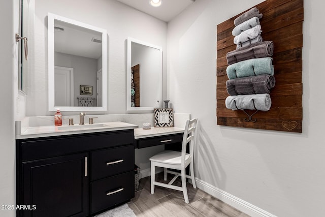 bathroom featuring visible vents, baseboards, and vanity